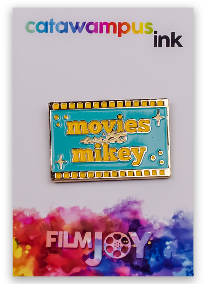 The Movies with Mikey enamel pin on a backing card.